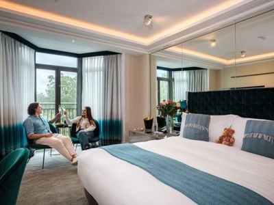 Couple drinking champagne in Athenaeum hotel bedroom