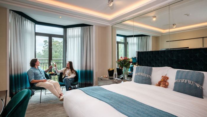 Couple drinking champagne in Athenaeum hotel bedroom