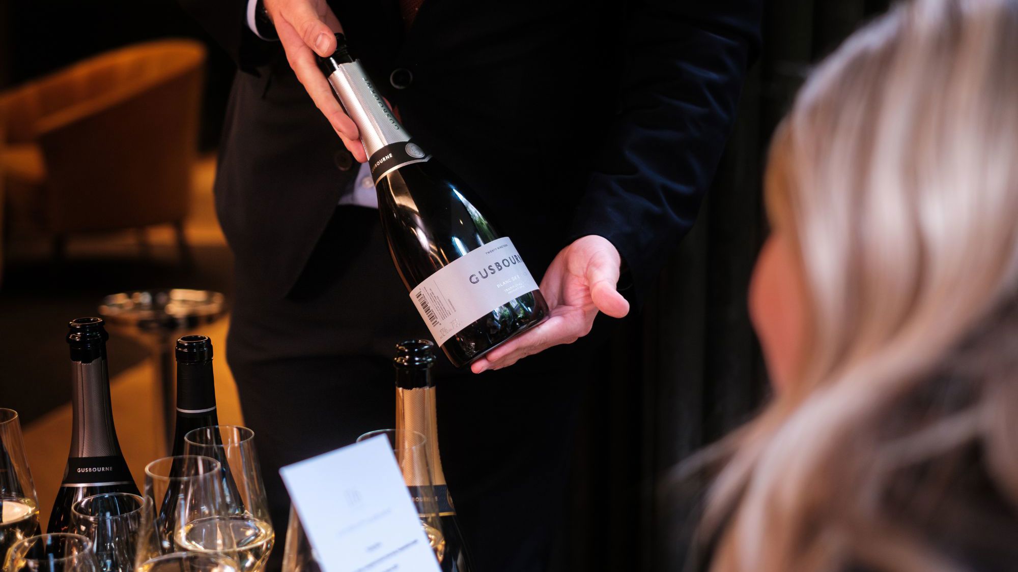 woman being shown a champagne bottle