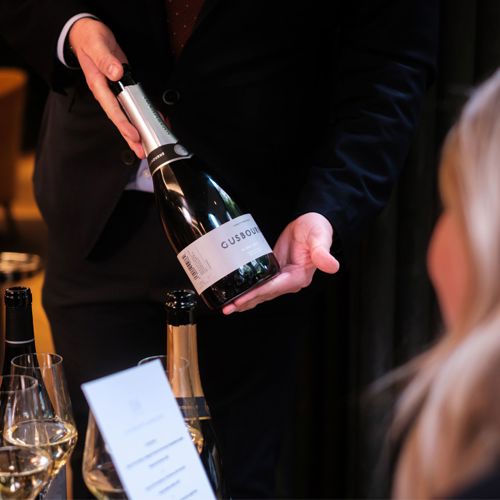 woman being shown a champagne bottle