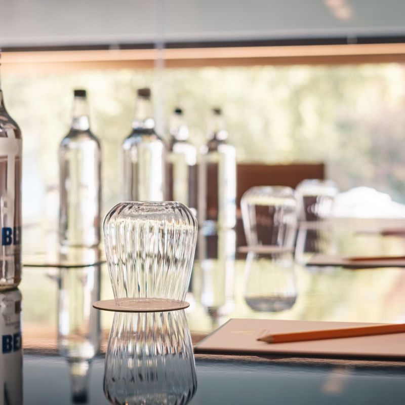 Meeting room table with bottles, glasses, pads and pencils