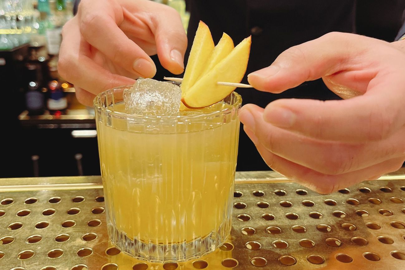 finishing a peach cocktail