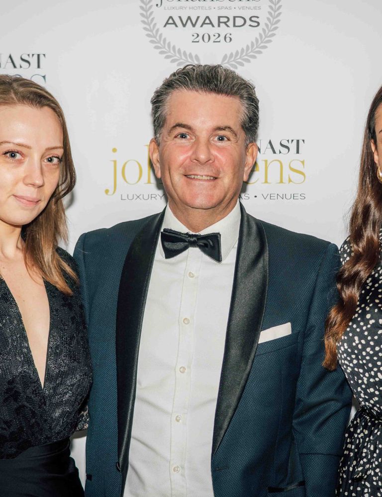 Three people by a press backdrop