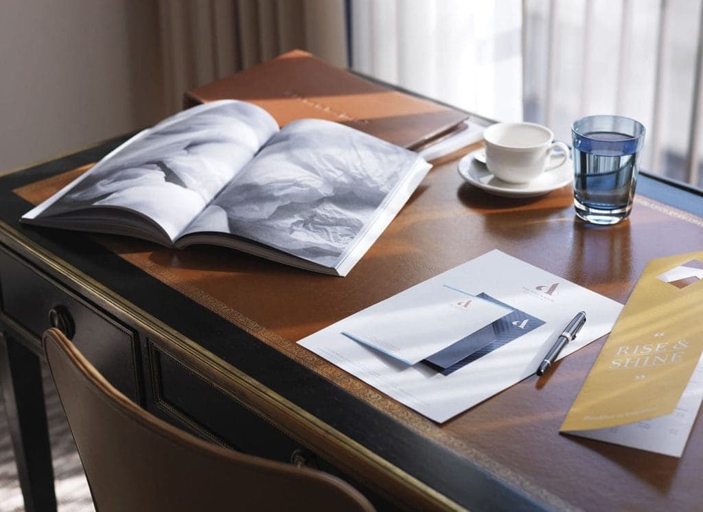 A workspace at The Athenaeum. The space includes a wooden desk and notebook.