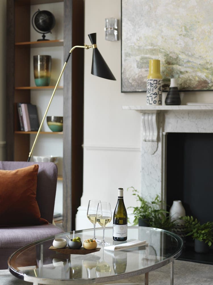 The living room area of a luxury serviced apartment in London. The room includes a coffee table and fireplace.