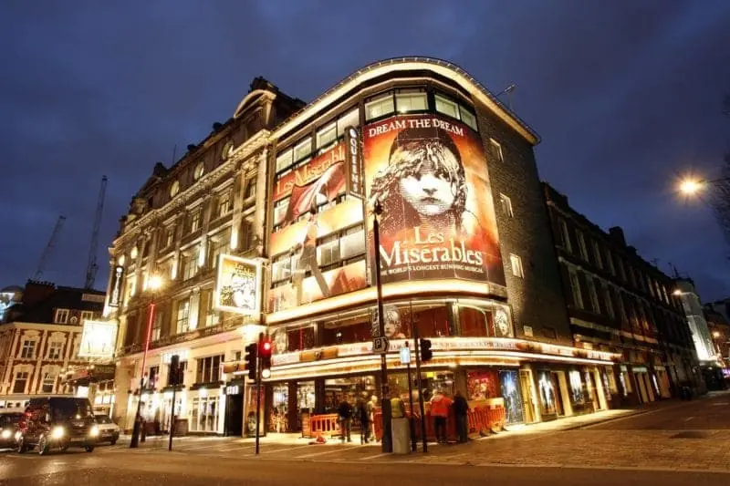 The West End theatre in London with a corner banner with a Les Misrables banner