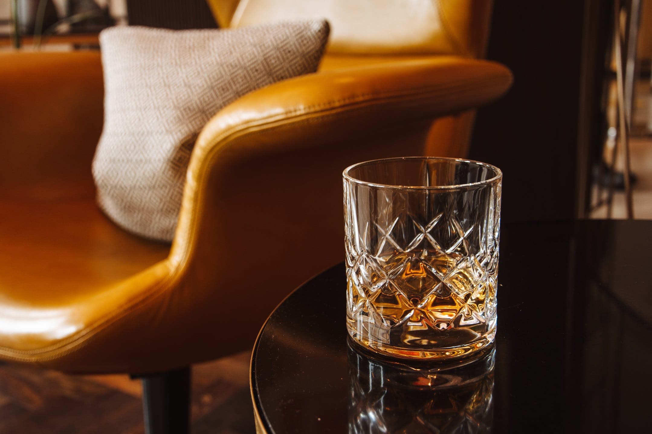 a glass of whisky sitting on corner table inside the Athenaeum's Mayfair cocktail bar